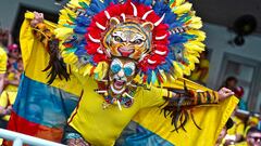 Un aficionado de Colombia posa para una fotografía con la bandera de su país y un sombrero con plumas y la cara de un tigre antes del partido de clasificación para el Mundial 2026 entre Colombia y Venezuela. Los hinchas cafeteros llenaron de colorido las gradas del Estadio Metropolitano en Barranquilla, Colombia. 