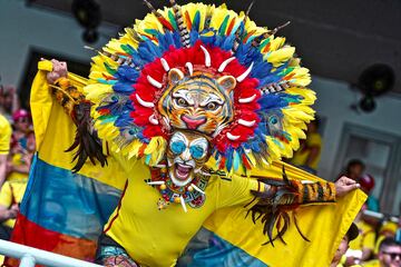 Un aficionado de Colombia posa para una fotografía con la bandera de su país y un sombrero con plumas y la cara de un tigre antes del partido de clasificación para el Mundial 2026 entre Colombia y Venezuela. Los hinchas cafeteros llenaron de colorido las gradas del Estadio Metropolitano en Barranquilla, Colombia.