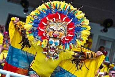 Un aficionado de Colombia posa para una fotografía con la bandera de su país y un sombrero con plumas y la cara de un tigre antes del partido de clasificación para el Mundial 2026 entre Colombia y Venezuela. Los hinchas cafeteros llenaron de colorido las gradas del Estadio Metropolitano en Barranquilla, Colombia.