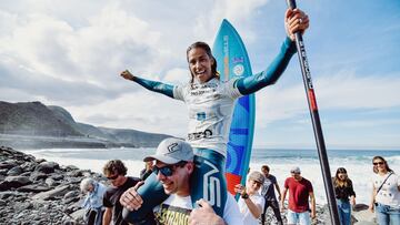 Iballa Ruano sale a hombros del agua en la Gran Canaria PRO-AM 2019, con la tabla de SUP detrás y el remo en la mano.