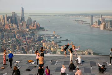 Un grupo de personas hace yoga en la azotea de un edificio de Manhattan (Nueva York). Como ocurre con muchos tipos de ejercicios al aire libre, esta práctica cogió gran demanda durante la pandemia del coronavirus, y no se ha pasado de moda, sino más bien al contrario: hay semanas de lista de espera para asistir a las clases.