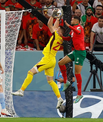 El portero español Unai Simón atrapa el balón por alto ante el jugador marroquí. 