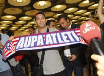 Arda a su llegada a Madrid posando con una bufanda del Atlético.