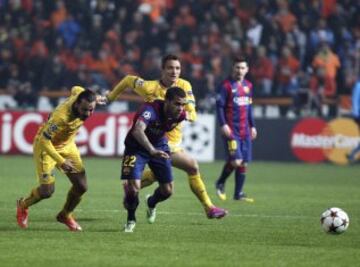 El defensa brasileño del FC Barcelona Dani Alves pelea por el control del balón con los jugadores del Apoel, Stathis Aloneftis y Gustavo Manduca, durante el partido del grupo F de la Liga de Campeones disputado en Nicosia, Chipre.