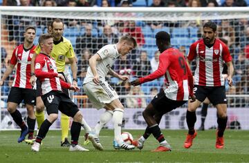 El jugador del Real Madrid Kroos intenta controlar el balón ante los jugadores del Athletic Club Muniain y Williams.
