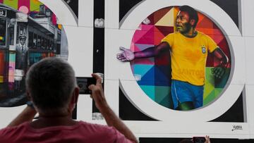 Un aficionado toma una fotografía a un cartel con la imagen de Pele.