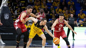 El base de La Laguna Tenerife, Marcelinho Huertas, ante los jugadores del Casademont Zaragoza, Marco Spissu y Emir Sulejmanovic.