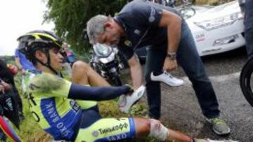 HUNDIDO. Alberto Contador es atendido por su mecánico Faustino Muñoz, que tuvo que cambiarle las zapatillas, rotas como consecuencia de la caída.