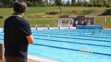 Un entrenador de natación observa un entrenamiento de su deportista.