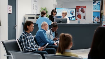 Waiting room in hospital lobby with reception counter desk, diverse people waiting to attend checkup visit appointment. Health care examination in emergency area at medical clinic.