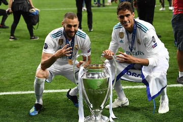 The team to beat | Real Madrid's French forward Karim Benzema and defender Raphael Varane gesture the number four as they pose with the trophy in 2018.