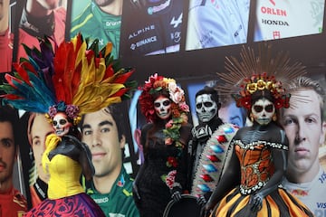 Aficionados vestidos con trajes de catrinas posan delante del  Autódromo Hermanos Rodríguez en el previo al GP de México.