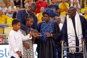Sitapaha Savané, acompañado por sus hijos y sus padres, pulsa el botón que descubrió su camiseta, que este sábado el club Baloncesto Gran Canaria retiró en homenaje al eterno capitán del equipo amarillo. 