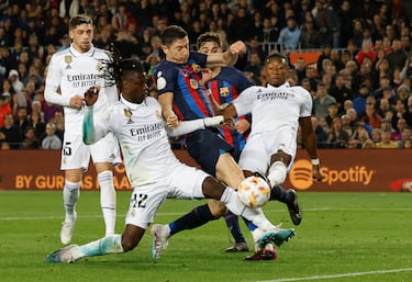 Robert Lewandowski intenta rematar entre los jugadores del Real Madrid, Eduardo Camavinga y David Alaba.