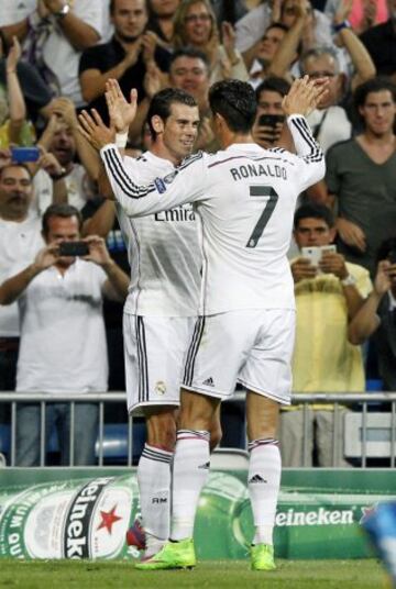 El delantero galés del Real Madrid Gareth Bale (i) celebra su gol, segundo del equipo, con el portugués Cristiano Ronaldo, durante el partido de la primera jornada de la fase de grupos de la Liga de Campeones que Real Madrid y FC Basilea disputan esta noche en el estadio Santiago Bernabéu, en Madrid.
