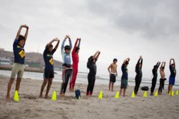 Clases de surf en una playa cerca de Alto Perú barrio de chabolas de Lima. Desde 2008, la ONG Alto Perú busca ofrecer a los niños de un barrio pobre de pescadores conocido como Alto Perú, la oportunidad de aprender y practicar deportes alternativos como el surf y el Muay Thai de forma gratuita.