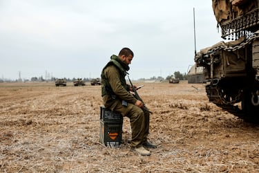 Un soldado israel se sienta sobre cajas de municiones cerca de un tanque Un soldado israel se sienta sobre cajas de municiones cerca de un tanque.