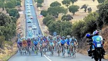 <b>TOBOGÁN. </b>El pelotón de Vuelta a España, a su paso por una larga recta que baja y sube, con un paisaje de encinas y carrascas en ambos lados de la carretera.