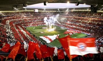 Spectators wave red and white flags, the colours of Bayern Munich, during the inauguration of the new Allianz Arena Football