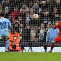Real Madrid's Ukrainian goalkeeper #13 Andriy Lunin saves the ball shot by Manchester City's Portuguese midfielder #20 Bernardo Silva during the penalty shootout during the UEFA Champions League quarter-final second-leg football match between Manchester City and Real Madrid, at the Etihad Stadium, in Manchester, north-west England, on April 17, 2024. (Photo by Paul ELLIS / AFP)