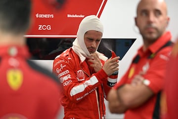 El piloto monegasco de Ferrari, Charles Leclerc (C), se rocía antes de la segunda sesión de práctica.