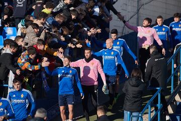 Los jugadores del Zaragoza chocan las cinco con los aficionados a su salida al terreno de juego.