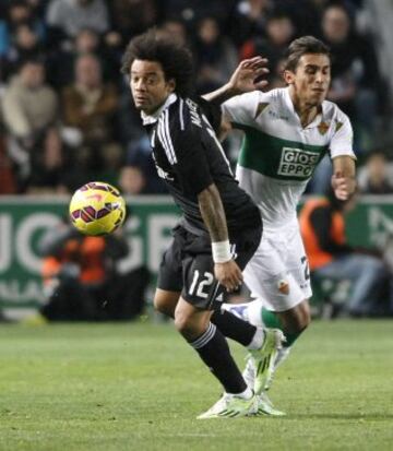 El defensa brasileño del Real Madrid Marcelo Vieira pelea un balón con el defensa uruguayo del Elche Damián Suárez.