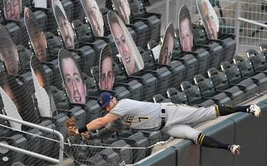 Eric Sogarg, de los Cerveceros de Milwaukee, salta contra la malla protectora para atrapar de forma espectacular una bola lanzada por Ehire Adrianza, de los Minnesota Twins. El partido, disputado en el Target Field de Minneapolis (Minnesota) ante un peculiar grupo de aficionados de cartón-piedra, se saldó con victoria de los Twins.
