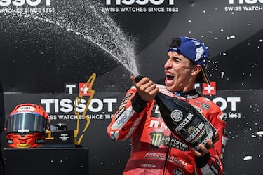 Marc Márquez celebra en el podio lanzando champán a los demás.