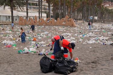Miembros del servicio de limpieza municipal de Málaga recogen restos de basura en la playa de La Malagueta.