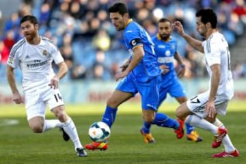 El centrocampista del Getafe Jaime Gavilán conduce el balón ante los jugadores de Real Madrid Xabi Alonso y Álvaro Arbeloa, durante el partido de la vigésimo cuarta jornada de liga de Primera División, disputado esta tarde en el Coliseo Alfonso Pérez.