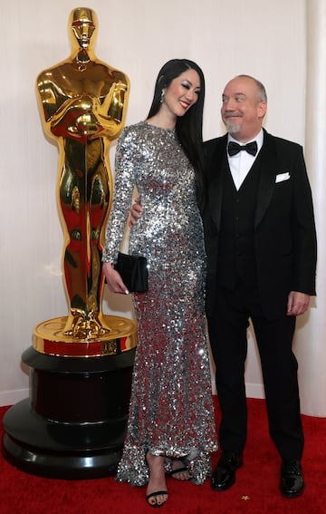 Paul Giamatti y Clara Wong posan a su llegada a la Gala de los Oscar.