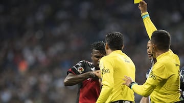 Marcos Quintero árbitro de la Liga MX tomando de la camiseta a Miller Bolaños delantero de Xolos