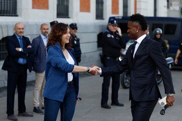 El delantero del Real Madrid Vinicius jr. es recibido por la presidenta de la Comunidad de Madrid, Isabel Díaz Ayuso, a su llegada a la Real Casa de Correos durante los actos de celebración de la trigésimo sexta Liga conseguida por el equipo este domingo en Madrid.