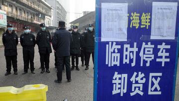 (FILES) This file photo taken on January 12, 2020 shows security guards standing in front of the closed Huanan wholesale seafood market, where health authorities say a man who died from a respiratory illness had purchased goods from, in the city of Wuhan, Hubei province. - January 11, 2021 marks the anniversary of China confirming its first death from the Covid-19 coronavirus -- a 61-year-old man who was a regular at the now-notorious Wuhan wet market linked to many of the early cases. (Photo by Noel Celis / AFP)