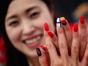 Una fan de Ferrari muestra sus uñas decoradas con ls banderas de Finlandia y de Alemania de sus pilotos (Raikkonen y Vettel).