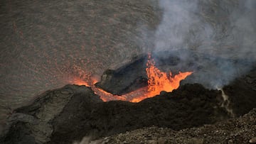 This photo courtesy of the US Geological Survey (USGS) shows lava erupts from the western vent within Halemax91umax91u crater, at the summit of K?lauea, on October 18, 2021. - Activity remains similar to previous days, with lava fountaining occurring through a perched pond within the vent cone and flowing down a short spillway into the lava lake. As lava enters the lake and moves away from the vent, the crust on the surface forms a radial pattern. (Photo by B. CARR / US Geological Survey / AFP) / RESTRICTED TO EDITORIAL USE - MANDATORY CREDIT "AFP PHOTO / B. CARR / USGS" - NO MARKETING - NO ADVERTISING CAMPAIGNS - DISTRIBUTED AS A SERVICE TO CLIENTS