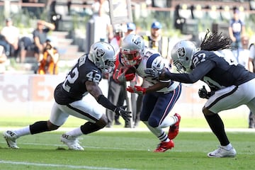 MEXICO CITY, MEXICO - NOVEMBER 19: Dion Lewis #33 of the New England Patriots splits a tackle from Karl Joseph #42 and Reggie Nelson #27 of the Oakland Raiders during the first half at Estadio Azteca on November 19, 2017 in Mexico City, Mexico.   Buda Mendes/Getty Images/AFP
== FOR NEWSPAPERS, INTERNET, TELCOS & TELEVISION USE ONLY ==