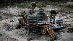 Ukrainian servicemen inspect a destroyed Russian tank near Kivsharivka village in a suburb of Kupiansk, Kharkiv region on December 15, 2022, amid the Russian invasion of Ukraine. (Photo by SERGEY BOBOK / AFP) (Photo by SERGEY BOBOK/AFP via Getty Images)