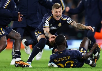 Real Madrid's German defender #22 Antonio Rudiger celebrates with teammates after scoring the winning penalty during the penalty shootout during the UEFA Champions League quarter-final second-leg football match between Manchester City and Real Madrid, at the Etihad Stadium, in Manchester, north-west England, on April 17, 2024. (Photo by Darren Staples / AFP)