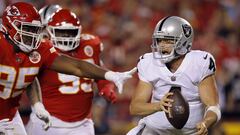 KANSAS CITY, MISSOURI - OCTOBER 10: Derek Carr #4 of the Las Vegas Raiders tries to evade Chris Jones #95 and Khalen Saunders #99 of the Kansas City Chiefs during the 2nd half of the game at Arrowhead Stadium on October 10, 2022 in Kansas City, Missouri.   David Eulitt/Getty Images/AFP