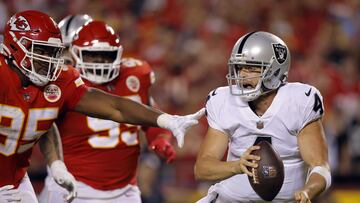 KANSAS CITY, MISSOURI - OCTOBER 10: Derek Carr #4 of the Las Vegas Raiders tries to evade Chris Jones #95 and Khalen Saunders #99 of the Kansas City Chiefs during the 2nd half of the game at Arrowhead Stadium on October 10, 2022 in Kansas City, Missouri.   David Eulitt/Getty Images/AFP