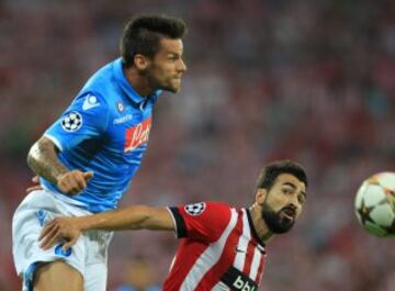 El defensa del Athletic Club Mikel Balenziaga (d) salta por el balón con el defensa Christian Maggio, del Nápoles, durante el partido de vuelta de la fase previa de la Liga de Campeones que se disputa esta tarde en el estadio de San Mamés, en Bilbao. 