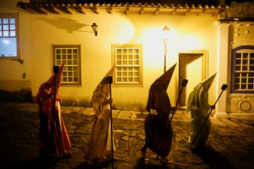 Fieles católicos encapuchados caminan en la Procesión de las Antorchas, conocida como Fogareu, durante la Semana Santa en Goiás, Estado de Goiás, Brasil.