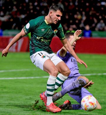 Nacho Fernández intenta despejar el balón que conduce David Grande.