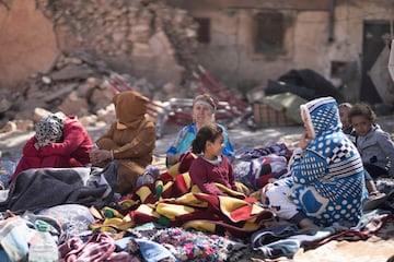 Familias sentadas afuera de sus casas destruidas después de un terremoto en la aldea de Moulay Brahim, cerca de Marrakech, Marruecos.