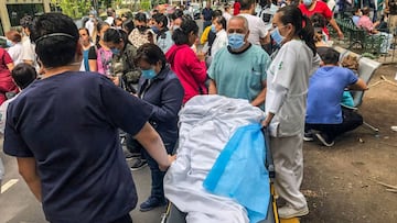 Health workers and patients remain outside the Durango clinic in Mexico City during a quake on June 23, 2020 amid the COVID-19 novel coronavirus pandemic. - A 7.1 magnitude quake was registered Tuesday in the south of Mexico, according to the Mexican National Seismological Service. (Photo by Pedro PARDO / AFP)