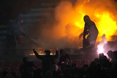 Un bombero extingue asientos en llamas durante un derbi de la liga nacional de fútbol de Serbia entre el Estrella Roja y el Partizán.