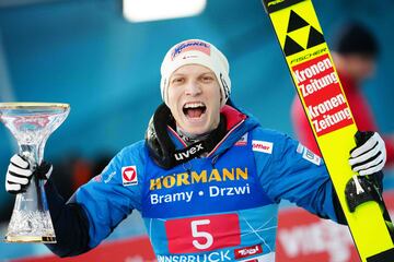 Jan Hoerl celebra su victoria con el trofeo de ganador en Innsbruck (Cuatro Trampolines).