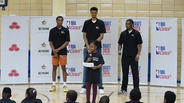 French basketball players Victor Wembanyama (C) and Bilal Coulibaly (L), with US player Cam Whitmore, listen to Mary McLeod Bethune School student Mia Lewis